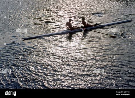 Two men in double skull rowing on calm water Stock Photo - Alamy