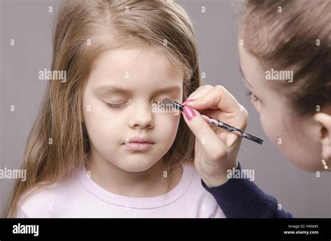 Makeup artist paints eyelids on girl's face Stock Photo - Alamy