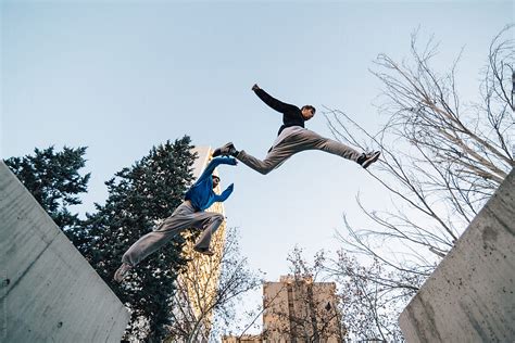 "Two Men Jumping During A Parkour Training At Sunset" by Stocksy Contributor "Inuk Studio" - Stocksy