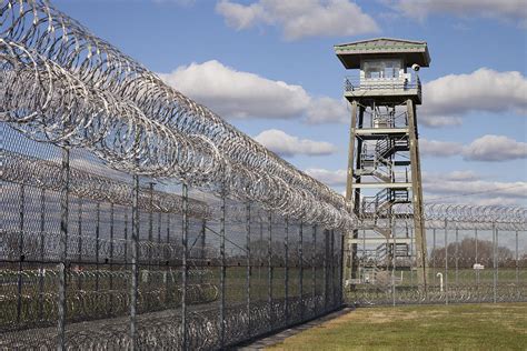 Prison Fence Watch Tower And Barbed Photograph by Roberto Westbrook