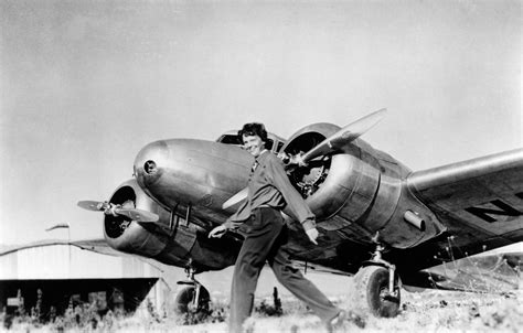 Amelia Earhart strides in front of her Lockheed Electra, the plane in which she disappeared in ...