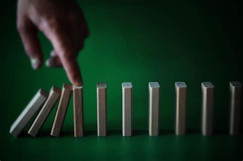 Concepto de efecto dominó con baldosas de madera bloqueadas por reloj de arena con fondo | Foto ...
