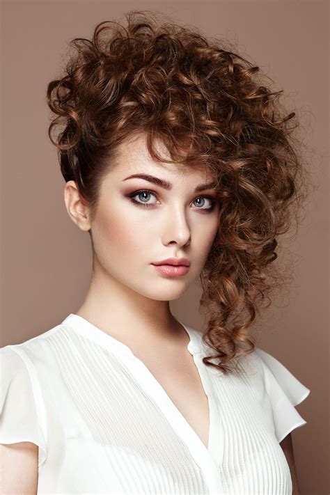 Brunette woman with curly and shiny hair. Beautiful model with wavy hairstyle. Fashion photo ...