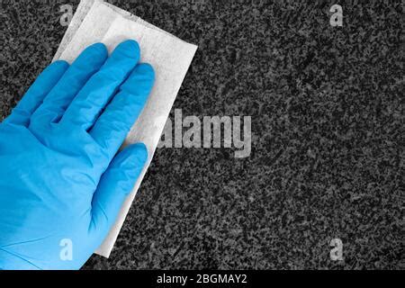 Cleaning white granite countertop worktop with a disposable cloth. Housework chores concept ...