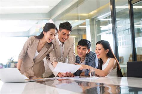 Young professional asian business people working with papers in office — handsome, smiling ...