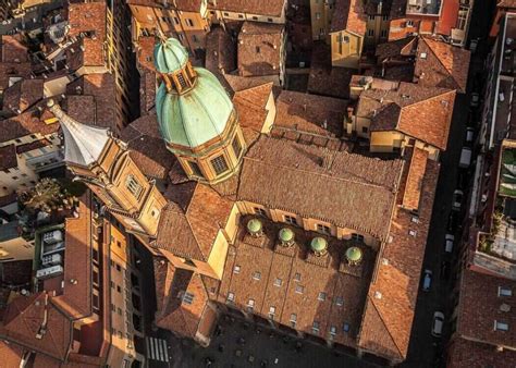 an aerial view of some buildings and rooftops with a clock tower in the ...