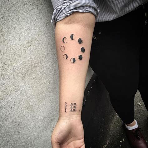 Circular black tattoo of lunar phases inked on the right inner forearm ...