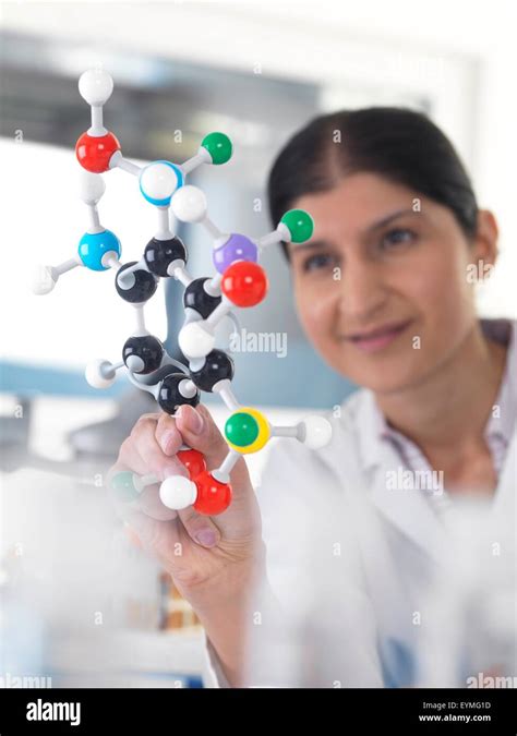 PROPERTY RELEASED. MODEL RELEASED. Female Asian using a molecular model to understand a chemical ...