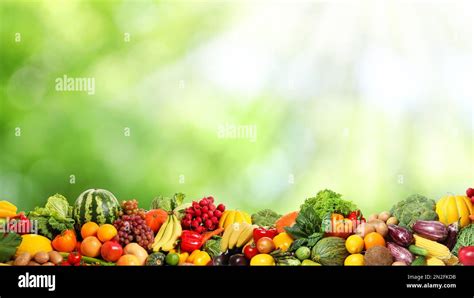 Assortment of fresh organic vegetables and fruits on blurred green ...