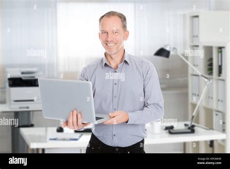 Happy Businessman Holding Laptop Stock Photo - Alamy