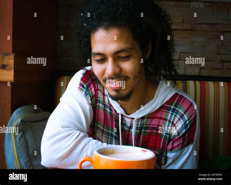 Adult Hispanic man drinking a cup of hot chai tea in a cafe Stock Photo - Alamy