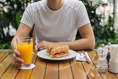 "Man Eating Breakfast In Cafe" by Stocksy Contributor "Mosuno" - Stocksy