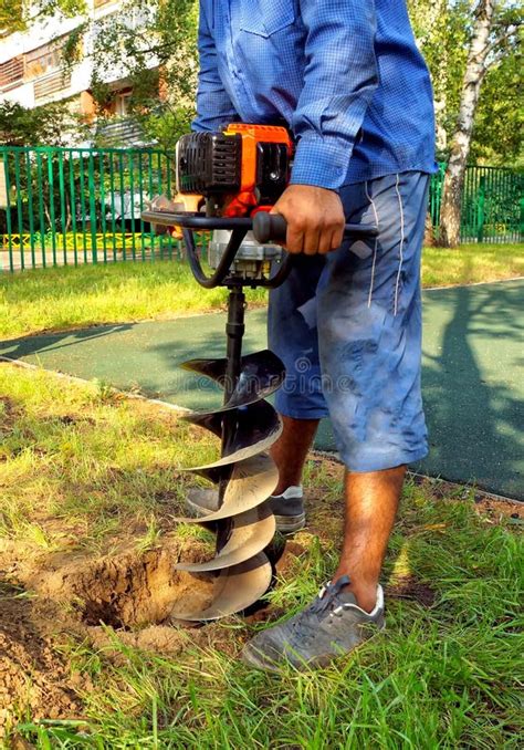 Worker Drilling Hole In The Ground Stock Photo - Image of hand, grass: 34879632