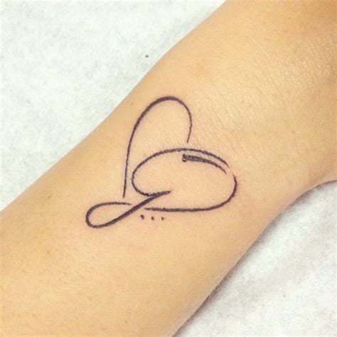 a woman's arm with a tattoo on it that has a heart in the middle