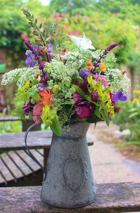 Early summer mixed bouquet in metal jug | Wild flower arrangements, Wild floral arrangements ...