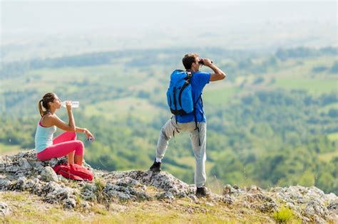 Premium Photo | Young couple hiking on the mountain