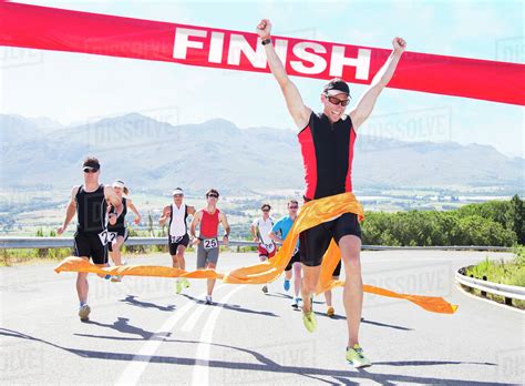 Runner crossing race finish line - Stock Photo - Dissolve