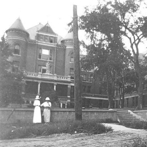 an old black and white photo of two women standing in front of a large ...