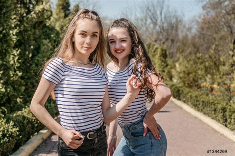 Two smiling young female girl friends having fun in park - stock photo ...