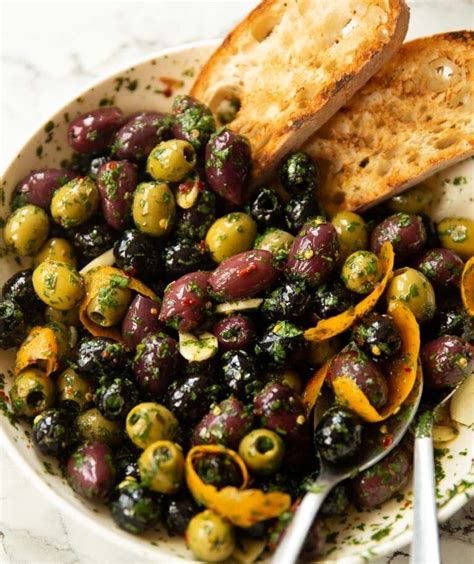 a white bowl filled with olives and bread