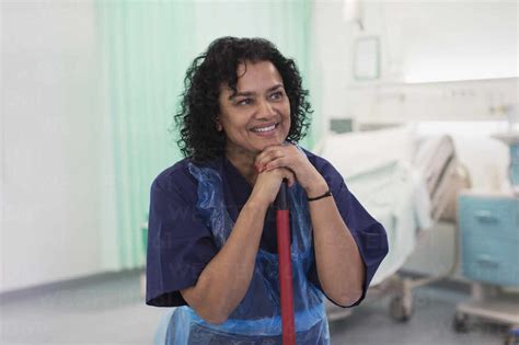 Smiling female orderly cleaning hospital ward stock photo