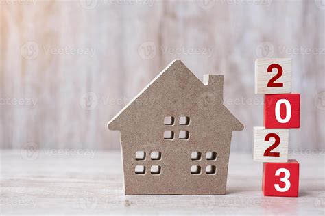 2023 Happy New Year with house model on table wooden background. Banking, real estate ...