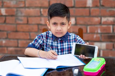 Little School Kid Learning from Mobile , he is Showing His Mobile Phone To the Camera. Indian ...