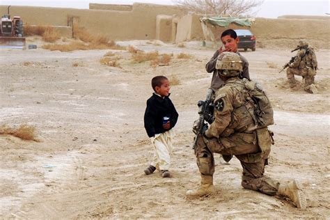 U.S. soldiers provide security and interact with local Afghan children during a leaders' shura ...