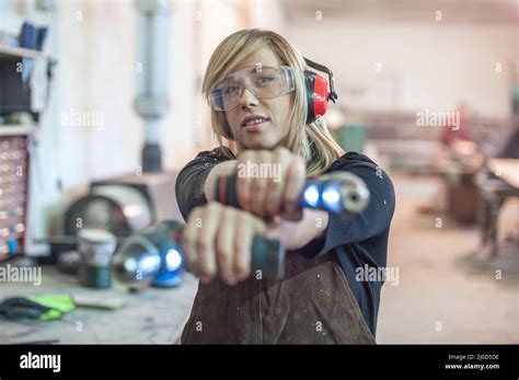 Female carpenter using power drill for wood Stock Photo - Alamy