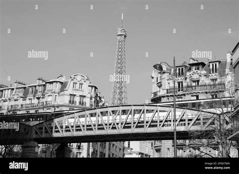 Paris cityscape with metro bridge (with passing train), Eiffel tower and French flag hanging out ...