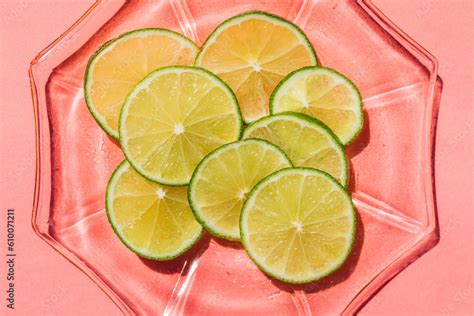 bright green sliced lime wheels on pink background in direct light Stock Photo | Adobe Stock