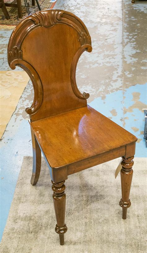 HALL CHAIRS, a pair, 19th century mahogany each with arched back. (2)