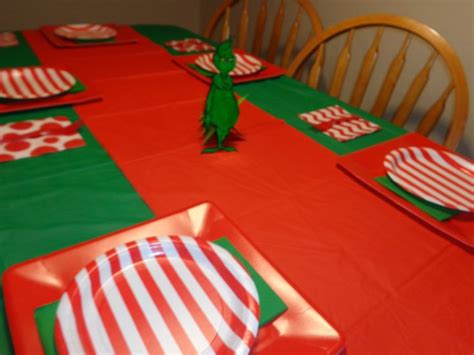 the table is set with red and green plates, napkins, and paper plates