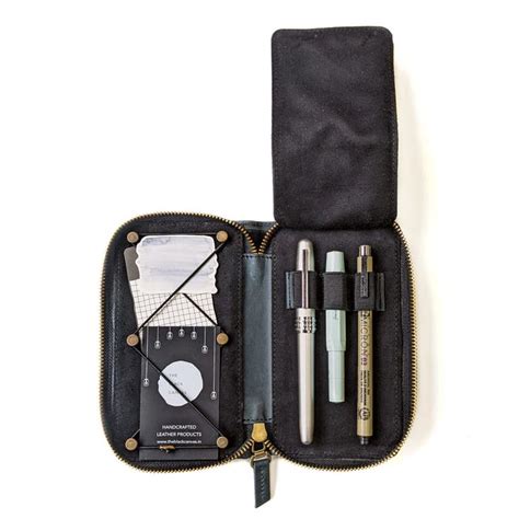 an open case with pens, notebooks and other items in it on a white background