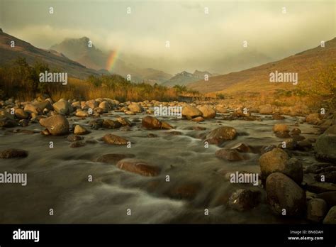 Sunrise on the Tugela River as weather pours over the Amphitheatre in Drakensberg Stock Photo ...