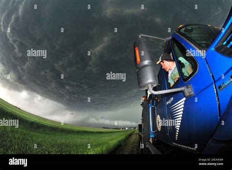 Storm chasing. Tornado researcher monitoring a severe thunderstorm from ...