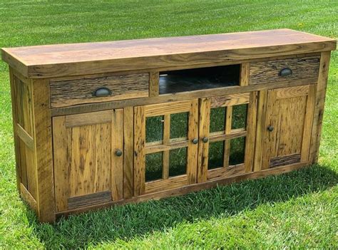 a wooden sideboard sitting on top of a lush green grass covered field ...