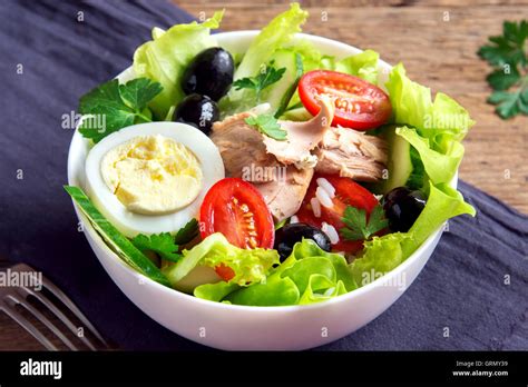 Ensalada de atún con huevo, tomate, aceitunas negras, arroz y verduras cerrar Fotografía de ...