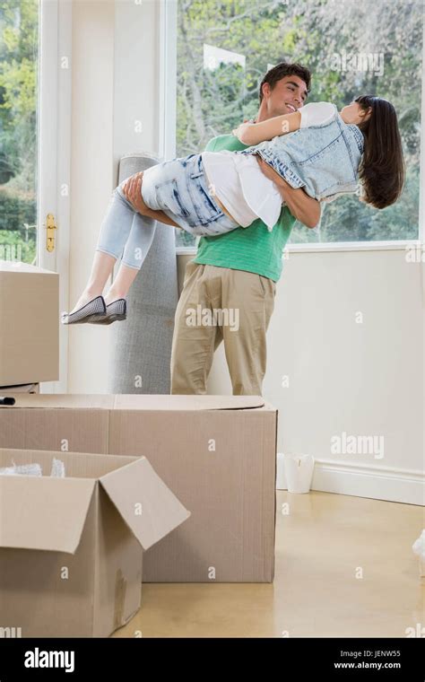 Young man lifting woman in his arms Stock Photo - Alamy