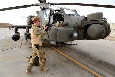 Military Armament | Prince Harry standing by an Apache helicopter at...