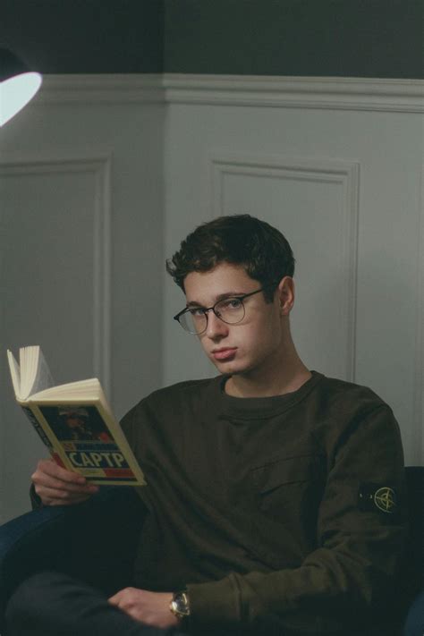 Man Sitting on Sofa Chair While Reading Book · Free Stock Photo