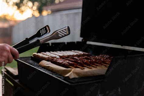 barbecue tongs and a backyard barbecue Stock Photo | Adobe Stock