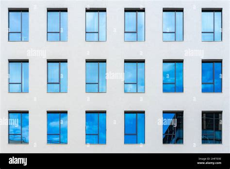 Abstract detail view of office building facade with lots of blue windows on a white wall, and ...