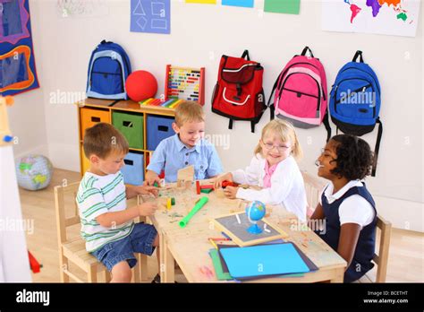 Four kids playing in preschool classroom Stock Photo - Alamy