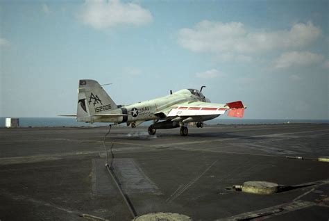 An A-6E Intruder aircraft engages an arresting cable while landing aboard the aircraft carrier ...