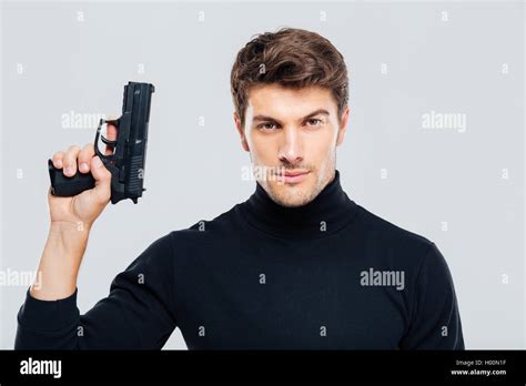 Portrait of handsome young man holding a gun Stock Photo - Alamy