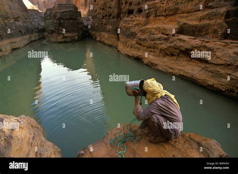 Algeria Djanet NP Tassili n Ajjer UNESCO World Heritage site Man of Tuareg tribe drinking water ...