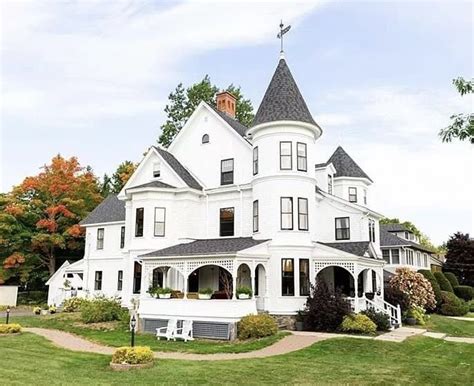 a large white house sitting on top of a lush green field