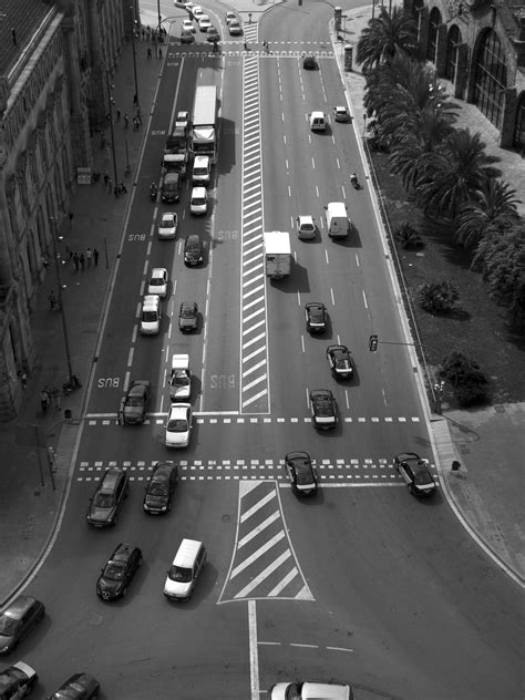 drone view of the multiple lane urban street between roundabouts filled with cars in barcelona ...