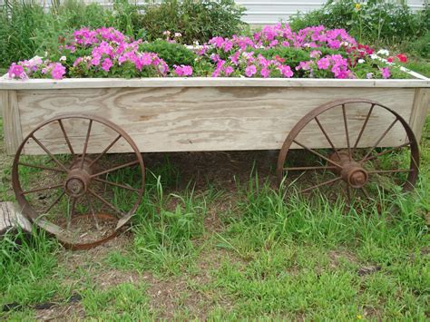 Old cart wheels sitting a planter's box. | Vertical garden planters, Garden planters diy ...